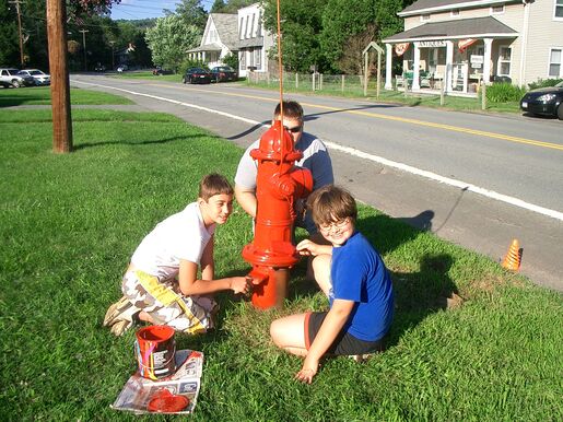 Three scouts from Troop 106 painting a fire hydrant