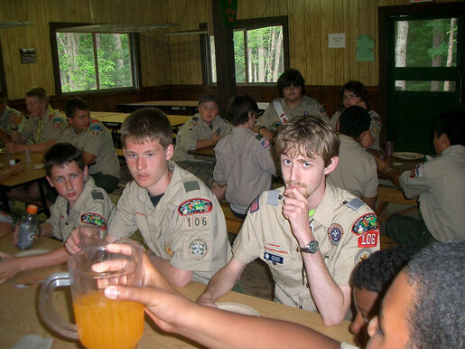 Troop 106 eating dinner with a staff member at summer camp