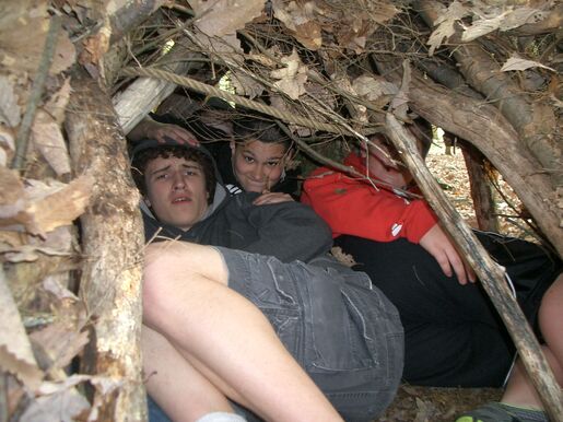 Scouts hiding in a wilderness survival shelter