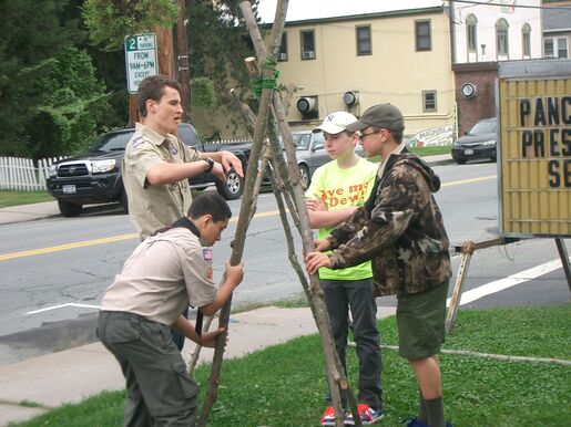 Four scouts tying a tripod in a yard in Jeffersonville